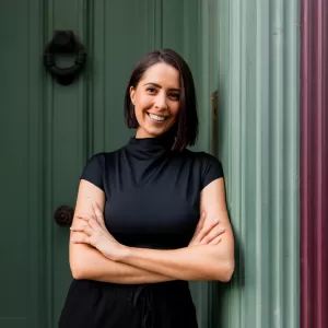 Photo of Laura Allen wearing black, leaning up against a wall
